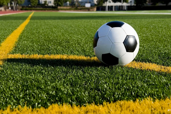 Pallone da calcio o calcio su un campo — Foto Stock