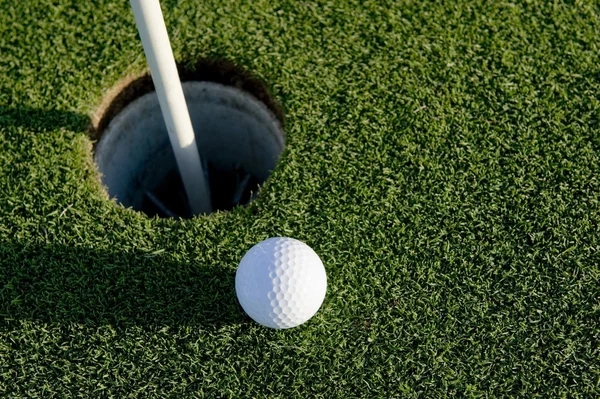 Golfbal in de buurt van hole — Stockfoto