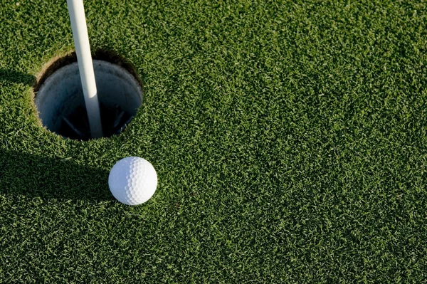 Golfbal in de buurt van hole — Stockfoto