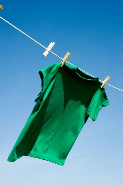 Een groene t-shirt op waslijn — Stockfoto