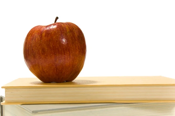 Libros escolares y manzana contra blanco — Foto de Stock