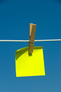 Yellow sticky note on a clothesline clipart