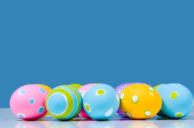 yansıması ile mavi arka plan üzerinde renkli Paskalya yumurtaları