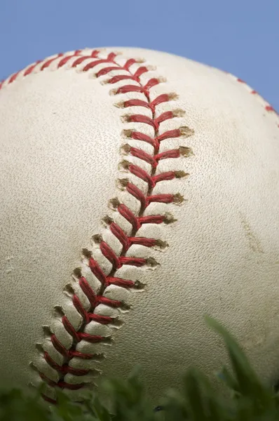 Бейсбол на траве против голубого неба — стоковое фото