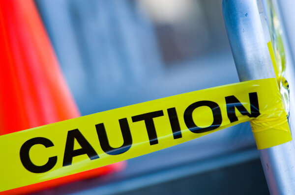 Caution tape with orange traffic cone