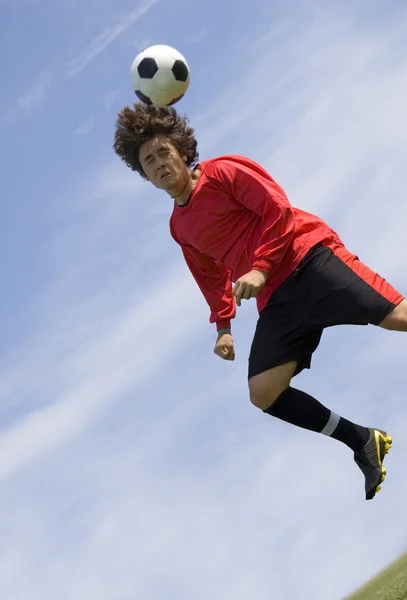 Futebol jogador de futebol fazendo cabeçalho — Fotografia de Stock