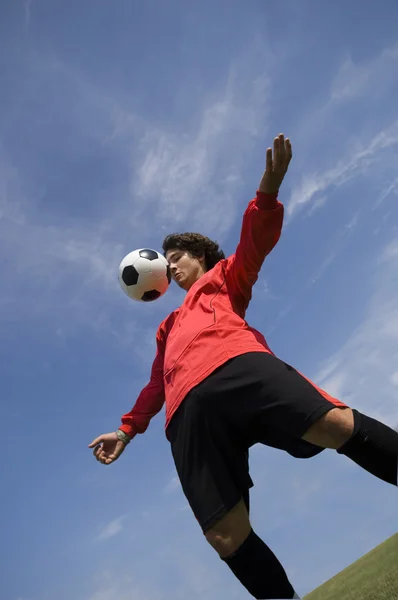 Futebol Jogador de futebol na bola de controle vermelho — Fotografia de Stock