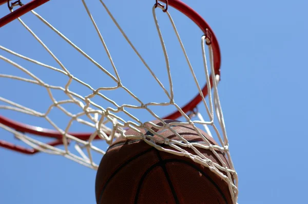 Basketball en cours à travers le filet — Photo