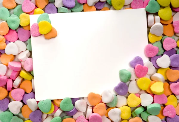 Blank note card surrounded, framed by candy hearts — Stock Photo, Image