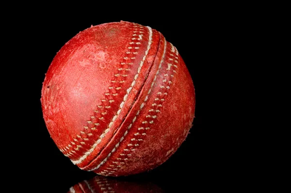 Rode cricket bal op zwarte achtergrond — Stockfoto