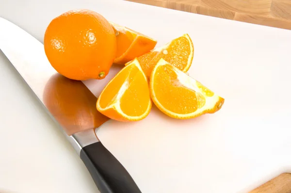 Frische geschnittene Orangen auf Schneidebrett mit Messer — Stockfoto