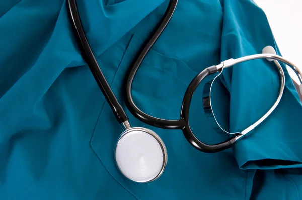 Stethoscope and scrubs on white background — Stock Photo, Image