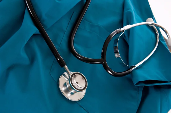 Stethoscope and scrubs on white background — Stock Photo, Image