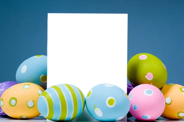 Huevos de Pascua de colores brillantes que rodean blanco, notecard en blanco —  Fotos de Stock