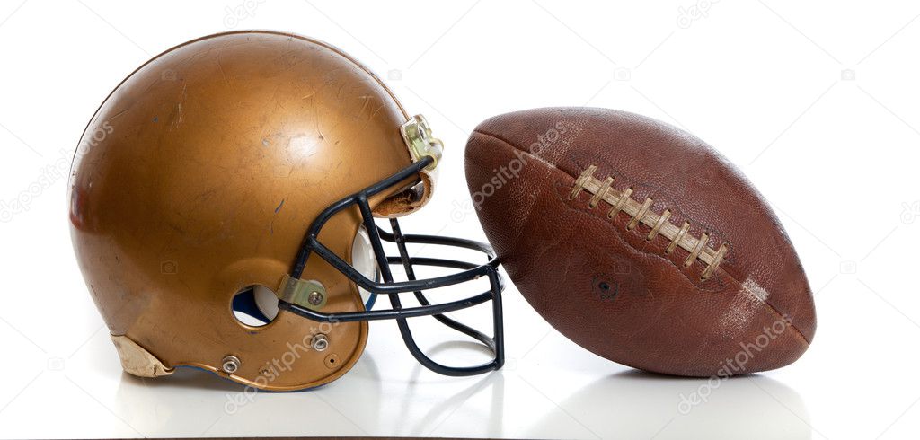 A retro gold football helmet and football on a white background Stock