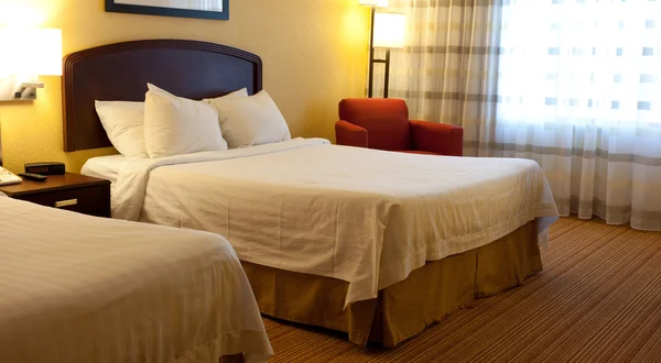 A hotel room with beds, chair and lamps — Stock Photo, Image