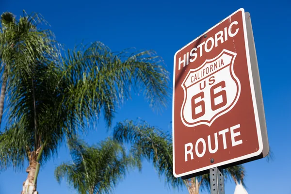 Señal histórica de la ruta 66 con palmera y cielo azul — Foto de Stock