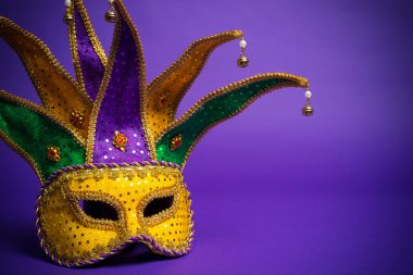 Assorted Mardi Gras or Carnivale mask on a purple background clipart