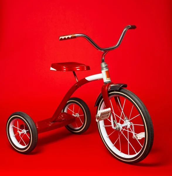 Vintage red tricycle on a bright red background — Stock Photo, Image