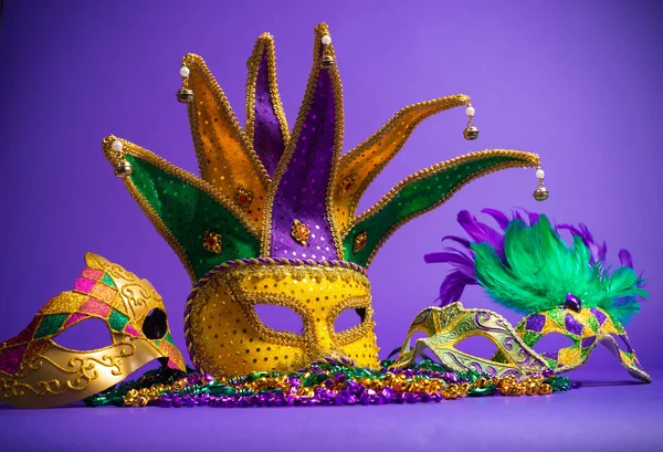 Ανάμικτες mardi gras ή carnivale μάσκα σε μοβ φόντο — Φωτογραφία Αρχείου