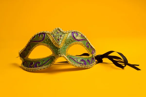 Verde e dourado Mardi Gras, máscara veneziana sobre fundo amarelo — Fotografia de Stock
