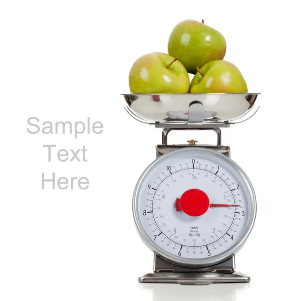 Fruta em uma escala com um fundo branco — Fotografia de Stock