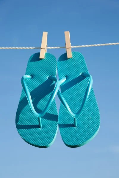 Um par de chinelos contra um céu azul — Fotografia de Stock