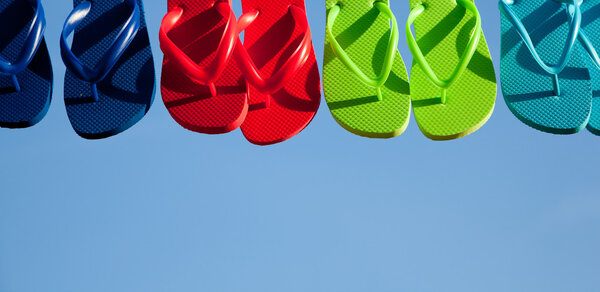 Row of flipflops against a blue sky