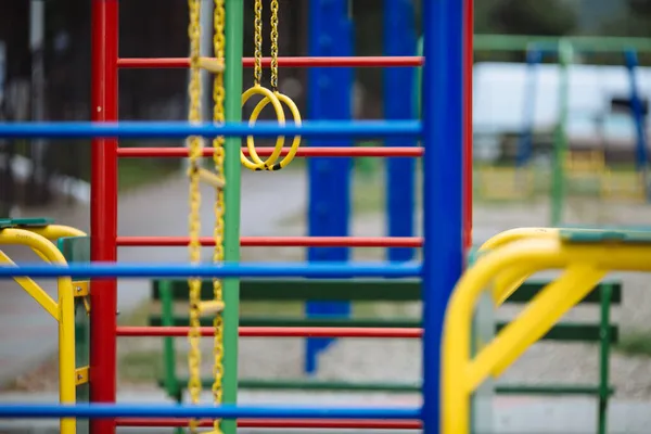 Renkli merdivenleri ve sarı jimnastik yüzükleri olan çocuk parkı için renkli ekipman.