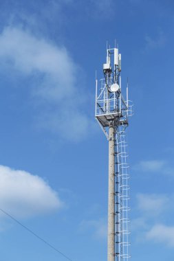 Yüksek telekomünikasyon kulesi ve mavi gökyüzüne karşı iletişim çanakları. Kablosuz uydu teknolojisi