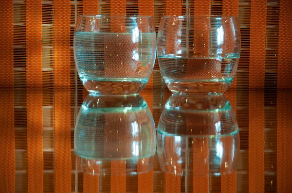 Vasos Con Agua Reflejos Sobre Fondo Cuadros Naranja — Foto de Stock