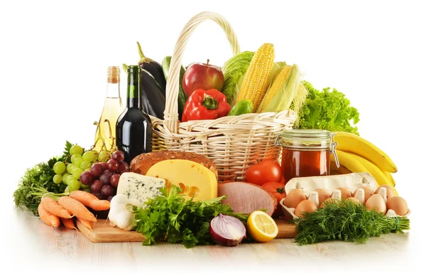 Zusammensetzung mit Lebensmitteln in Weidenkorb auf Küchentisch — Stockfoto