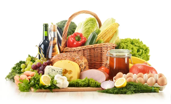 Composition with groceries in wicker basket on kitchen table — Stock Photo, Image