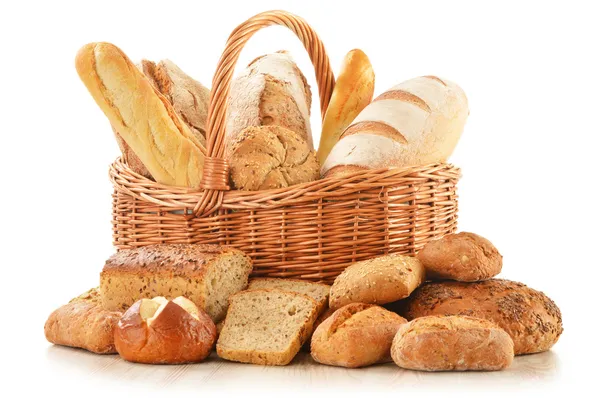 Хлеб и рулоны в плетеной корзине изолированы на белом — стоковое фото