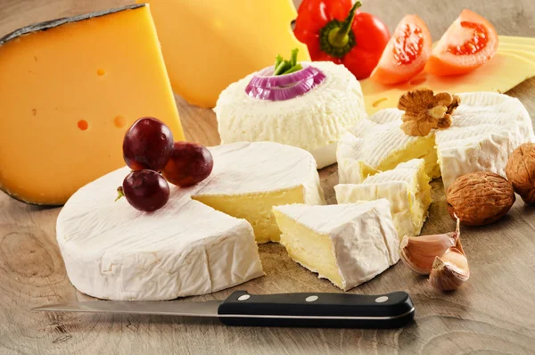Kompozycja z różnych rodzajów sera na drewnianym stole — Zdjęcie stockowe