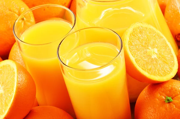 Композиция с двумя стаканами апельсинового сока и фруктами — стоковое фото