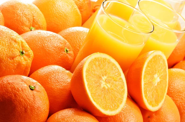 Composición con dos vasos de zumo de naranja y frutas — Foto de Stock