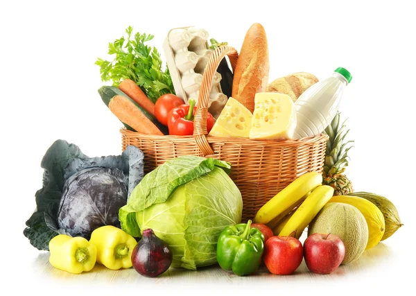 Panier en osier avec variété de produits d'épicerie isolés sur blanc — Photo