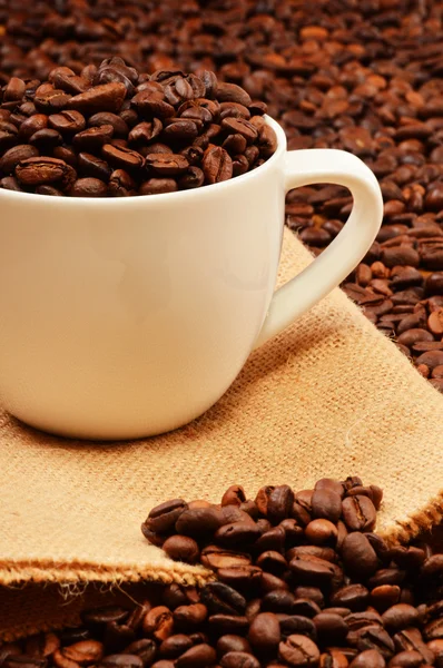 Composição com xícara branca e grãos de café — Fotografia de Stock