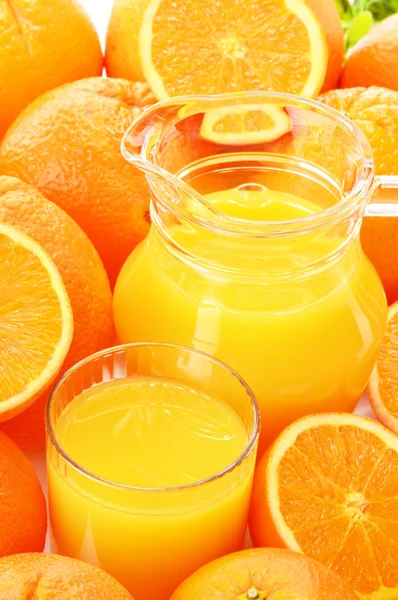 Glass and jug of orange juice and fruits — Stock Photo, Image