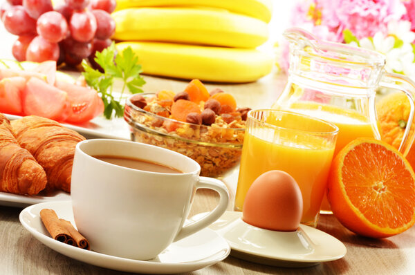 Breakfast with coffee, orange juice, croissant, egg, vegetables