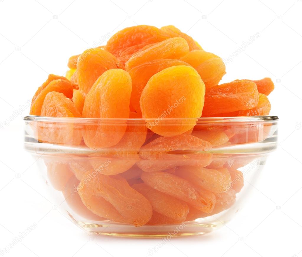 Glass bowl with dried apricots isolated on white