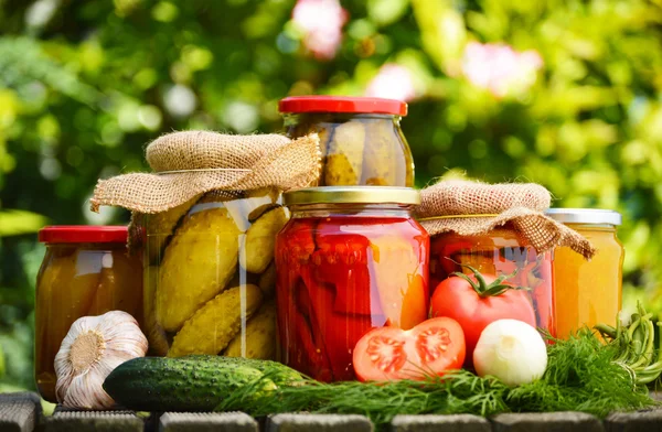 Potten van ingemaakte groenten in de tuin. gemarineerde voedsel — Stockfoto