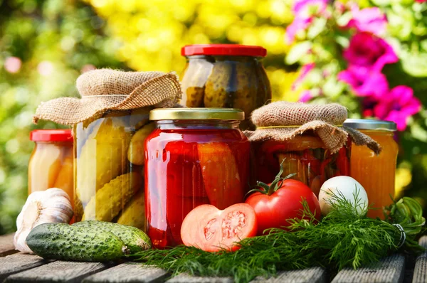 Potten van ingemaakte groenten in de tuin. gemarineerde voedsel — Stockfoto