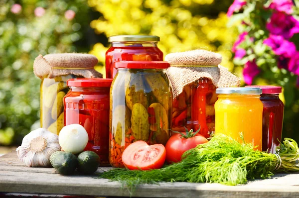 Potten van ingemaakte groenten in de tuin. gemarineerde voedsel — Stockfoto