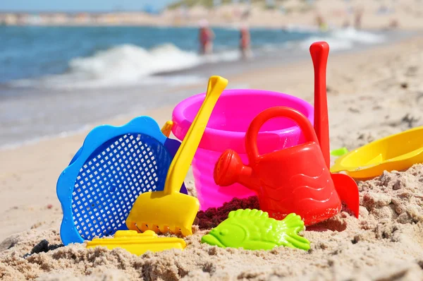 Plástico crianças brinquedos na praia de areia — Fotografia de Stock