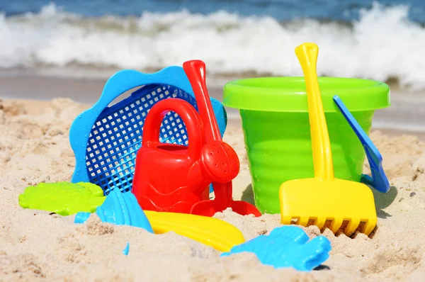 Plástico crianças brinquedos na praia de areia — Fotografia de Stock