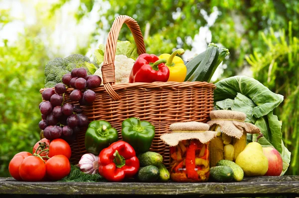 Свежие органические овощи в плетеной корзине в саду — стоковое фото
