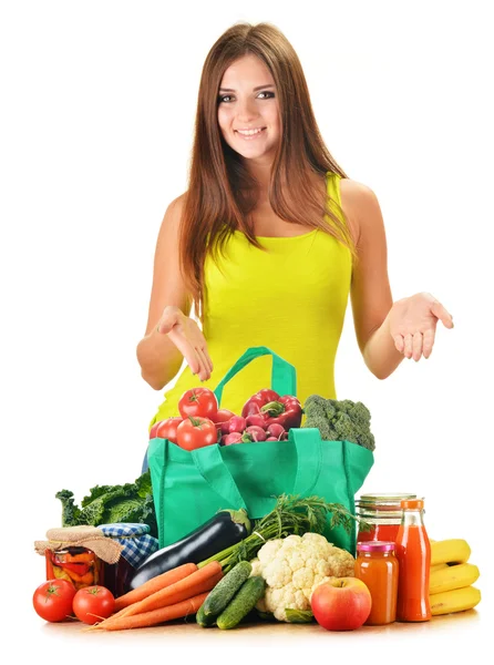 Jonge vrouw met verscheidenheid van kruidenier producten in winkelwagen — Stockfoto