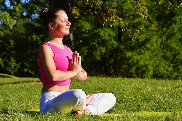 Young woman during yoga meditation in the park — Stock Photo, Image